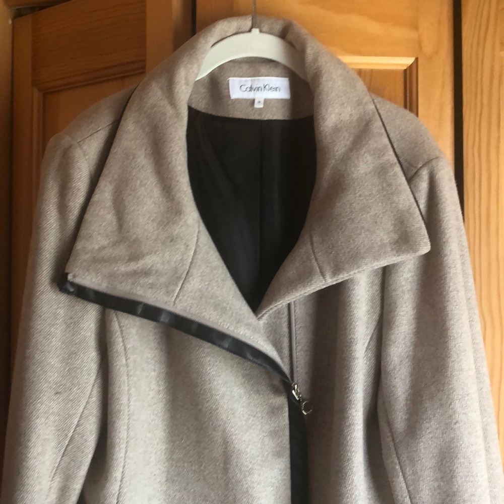 Tan wool medium length winter jacket. Leather trim on sleeves and pockets.